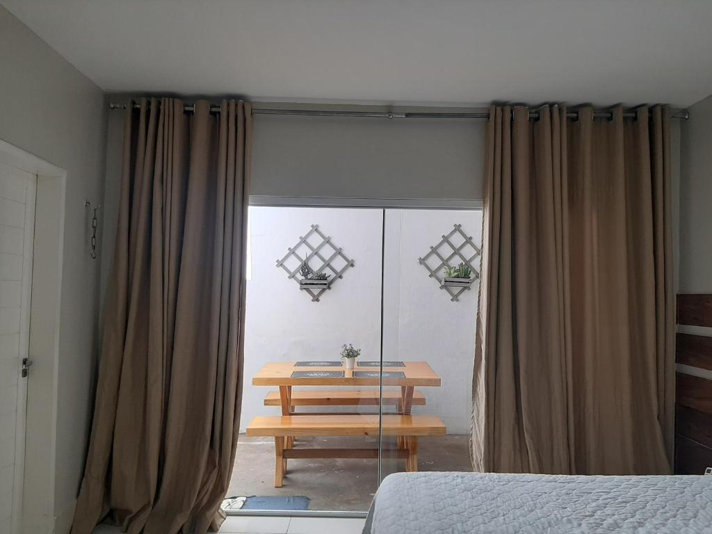 a bedroom with a table and a window with curtains at FlatStudio05 na Nova Betânia - INNOVA in Mossoró