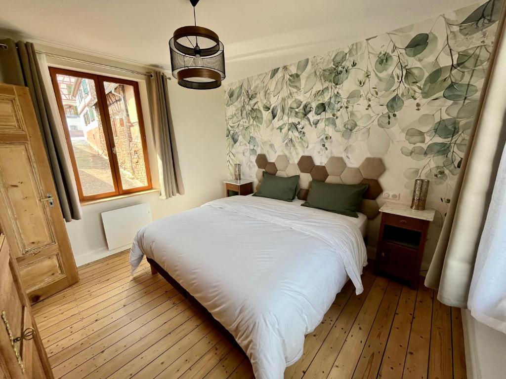 1 dormitorio con 1 cama con sábanas blancas y almohadas verdes en Gîte Ô Gré des Vosges 5 Étoiles Oberbronn, Vosges du Nord, en Oberbronn
