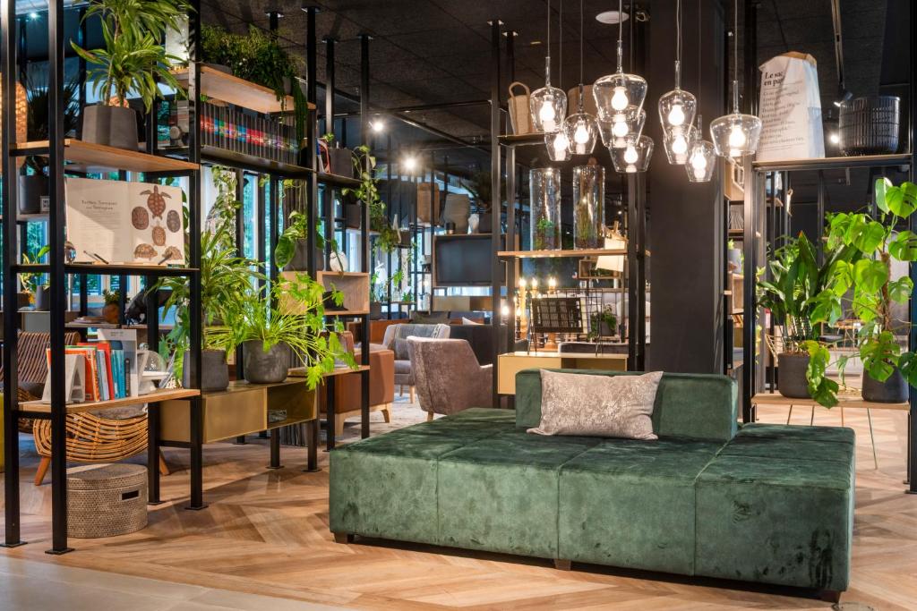 a living room with a green ottoman and plants at Flightgate Munich Airport Hotel, a member of Radisson Individuals in Hallbergmoos