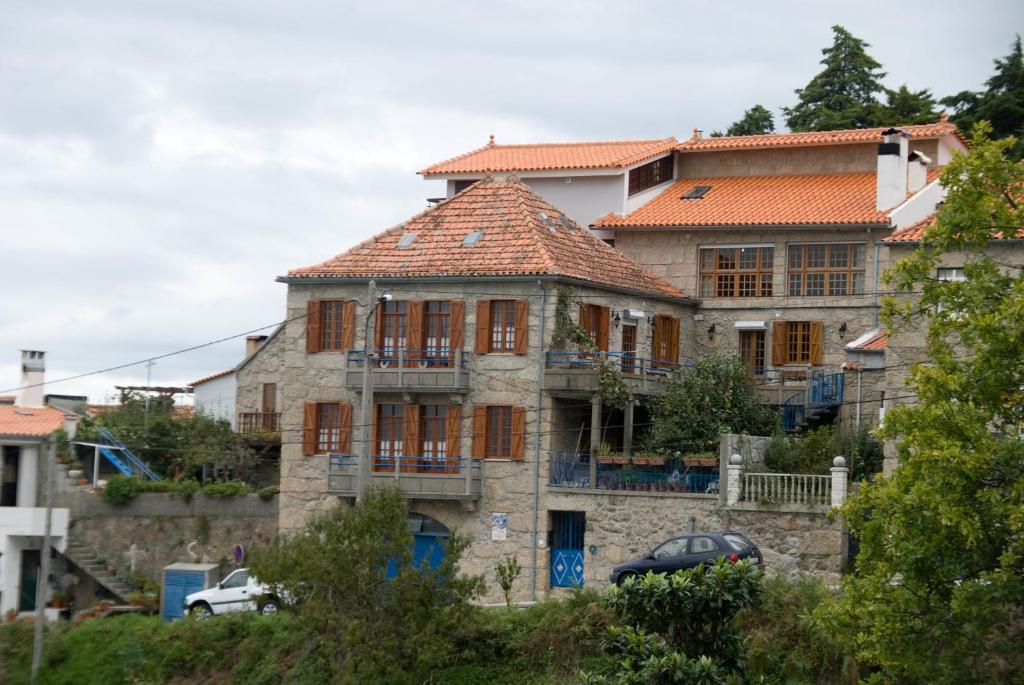 een oud stenen huis met een rood dak bij Casa Na Montanha Da Neve in Seia