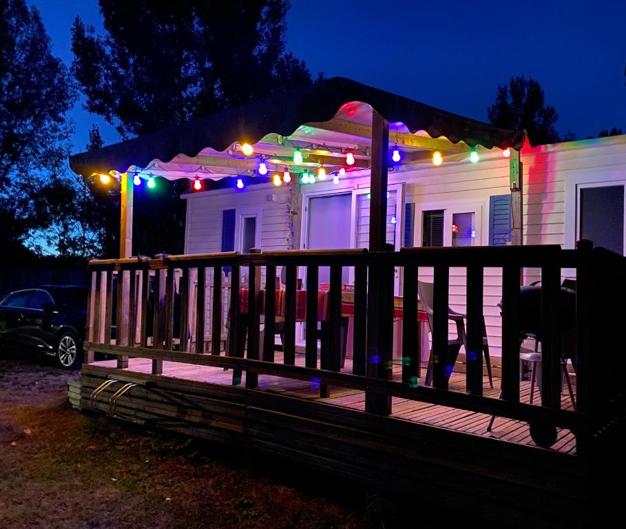 a house with an umbrella and christmas lights on it at Mobilhome Santerre in Châtillon-sur-Broué