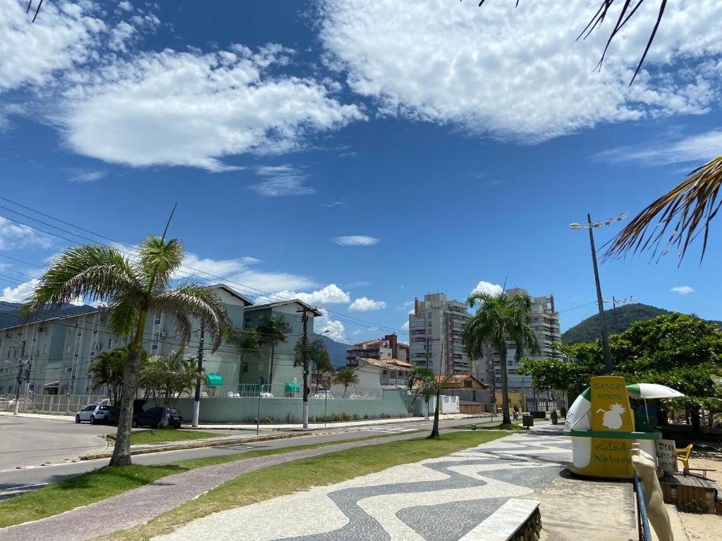 una calle con palmeras y un cielo azul en Desfrute bons momentos a beira mar com diária 24h, en Caraguatatuba