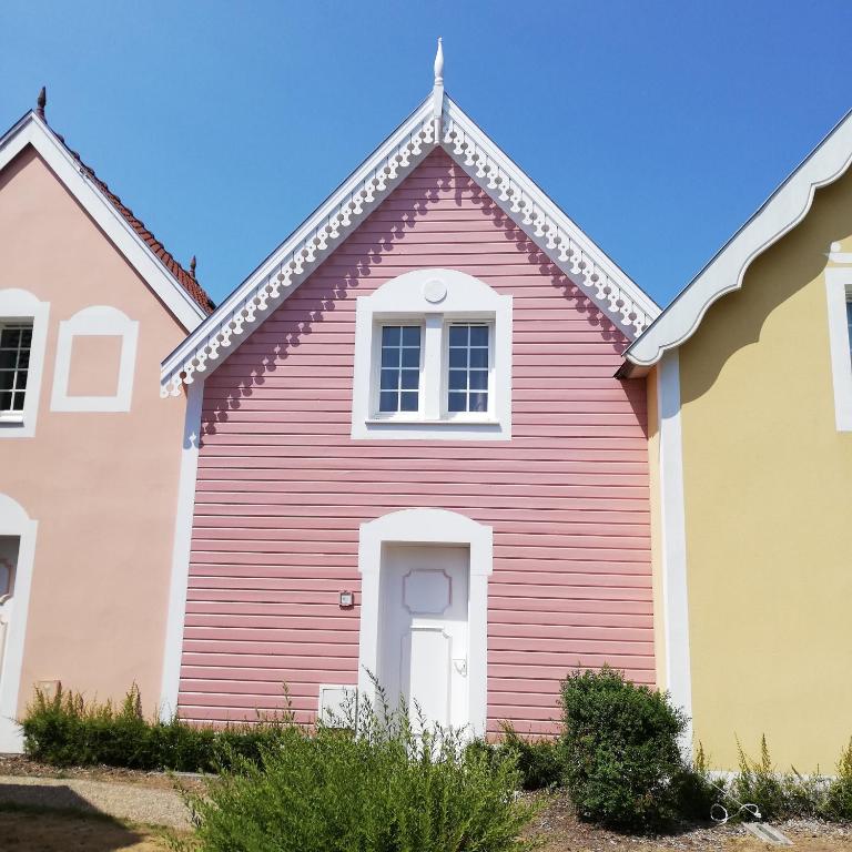une maison rouge avec une porte blanche dans l'établissement La Maison Rose, à Fort-Mahon-Plage