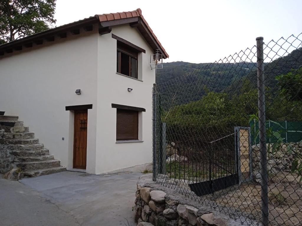 a white house with a fence and a gate at El Payarin tu casa apartamento en Asturias in Bárzana