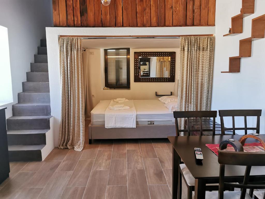 a bedroom with a bed and a staircase with a table at Moscha's View House in Lipsoi