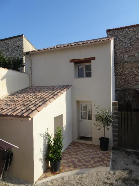 une maison blanche avec une porte et un portail dans l'établissement Maisonnette OCELIA 2 personnes Port de la Madrague, à Marseille