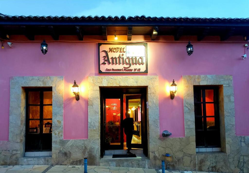 un edificio rosa con un cartel para una tienda de antigüedades en Hotel Antigua en San Cristóbal de Las Casas