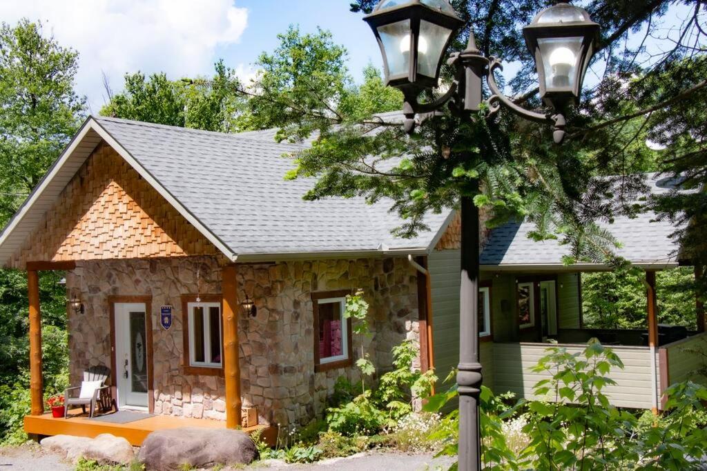 a small stone house with a street light at Chalet L'Envolée near Tremblant in Saint-Faustin