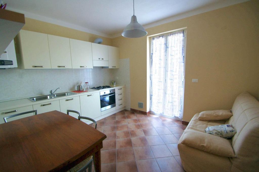 eine Küche und ein Wohnzimmer mit einem Sofa und einem Tisch in der Unterkunft Agriturismo Mulino del Castello Nasino in Nasino