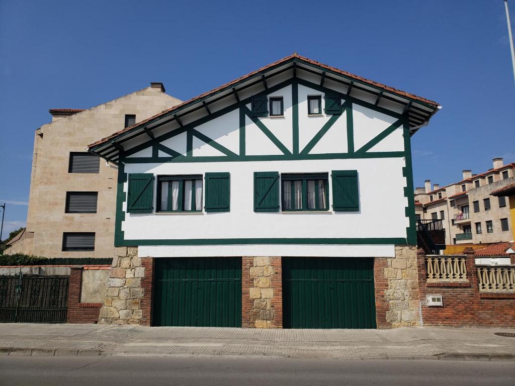 un edificio de color verde y blanco en Casa Vasca, en Llanes