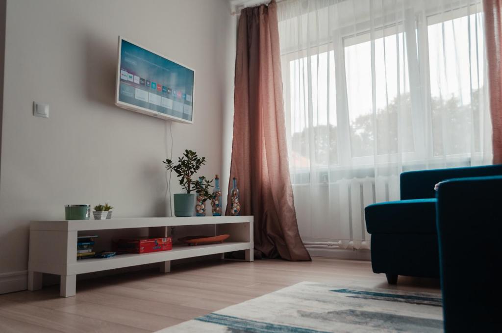 a living room with a blue couch and a large window at Rīgas ielas apartamenti 1 in Valmiera