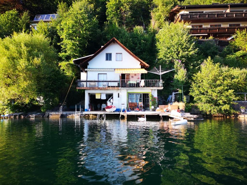 a house on a dock on a body of water at DasHausAmSee in Döbriach