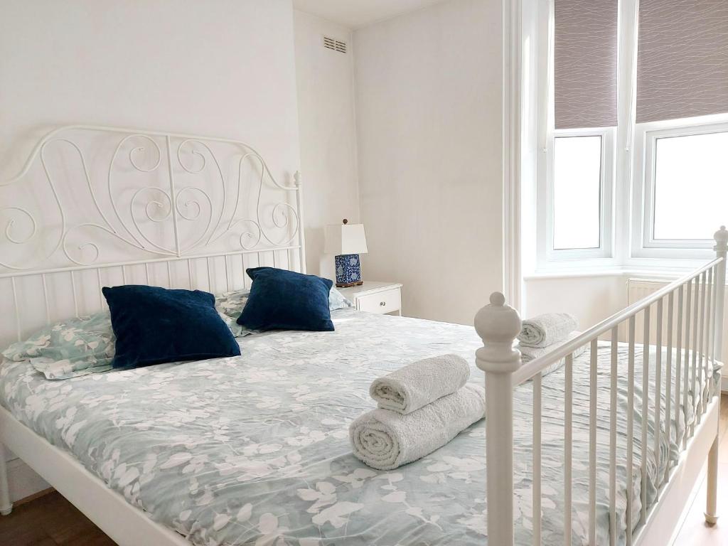 ein weißes Bett mit blauen Kissen im Schlafzimmer in der Unterkunft Cosy Central Canterbury - Modern Victorian in Kent