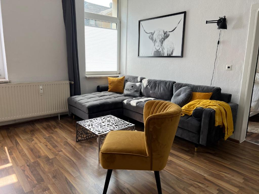 sala de estar con sofá y silla en Gemütliche Ferienwohnung mit gratis Netflix en Glauchau