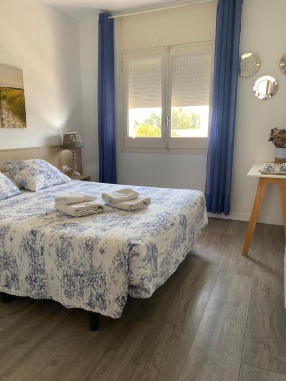 レスタルティットにあるApartamento Costa Bravaのベッドルーム1室(ベッド1台、青いカーテン付きの窓付)