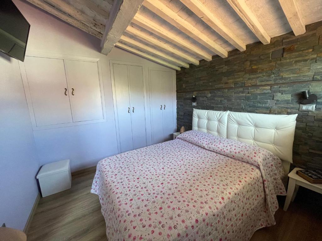 a bedroom with a bed and a brick wall at IL CAPPELLAIO MATTO in Livorno