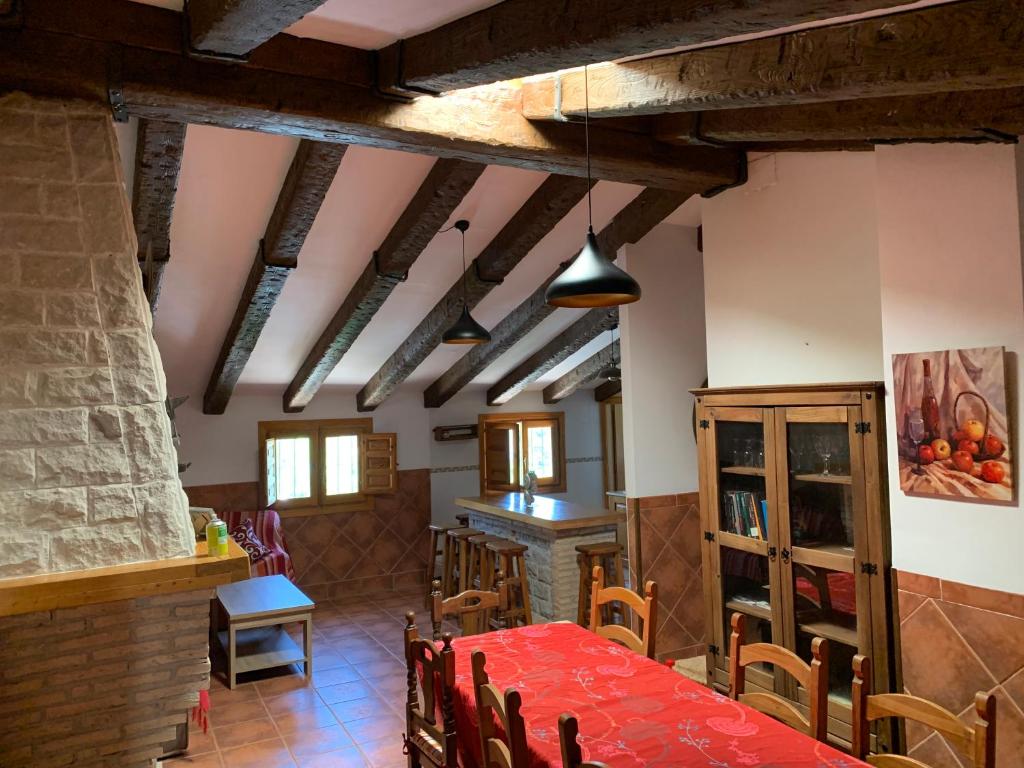 une salle à manger avec une table et des chaises rouges dans l'établissement Apartamento Rural Cardera en la Sierra de Cazorla, à Beas de Segura