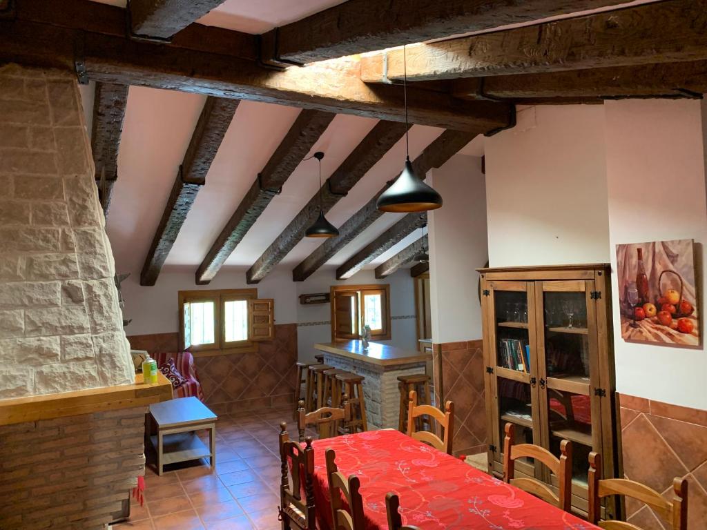 uma sala de jantar com uma mesa vermelha e cadeiras em Apartamento Rural Cardera en la Sierra de Cazorla em Beas de Segura