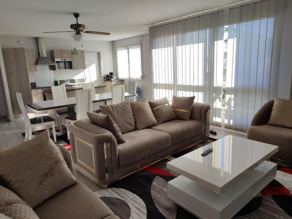 a living room with a couch and a table at Grand et superbe appartement proche Paris in Creil