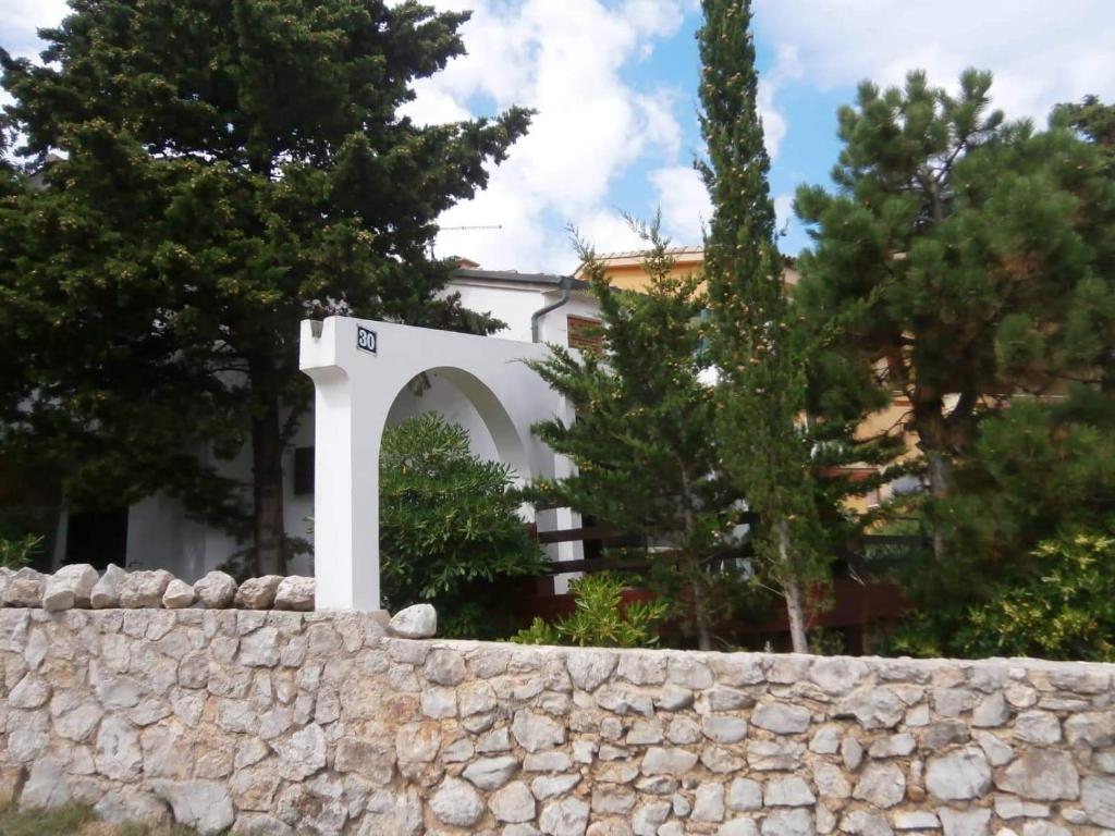 a stone fence in front of a building at Apartments Olea in Baška