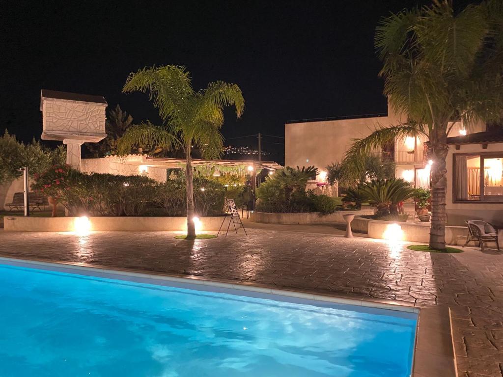 a swimming pool in front of a house at night at Le Zarafe in Caltabellotta