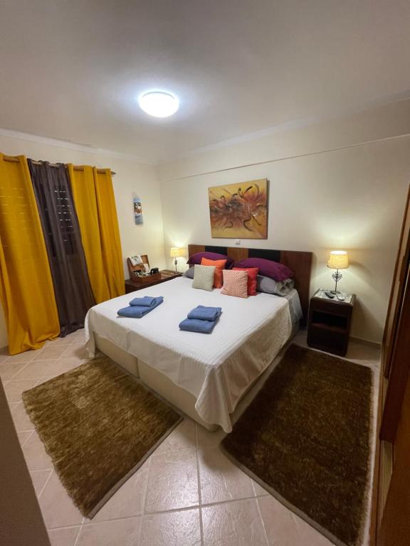 a bedroom with a large bed with blue towels on it at Casa #SerJo in São Brás de Alportel