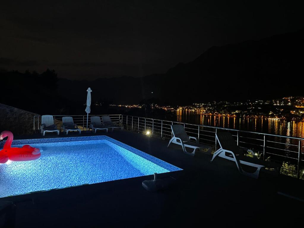 una piscina notturna con vista sulla città di Apartments Seaview Estate Radovic a Kotor (Cattaro)