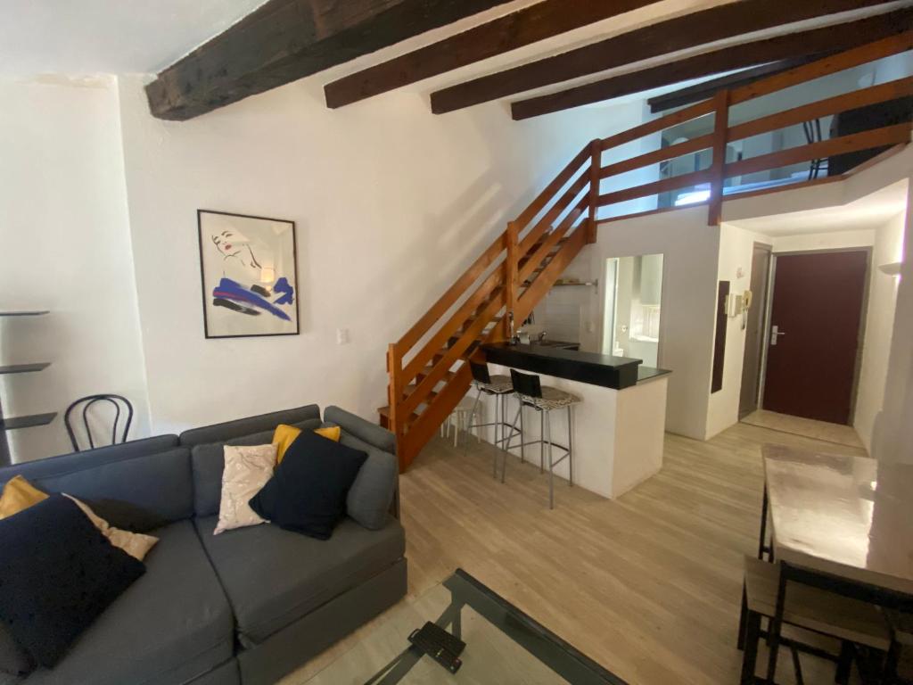 un salon avec un canapé et un escalier dans l'établissement Le Cocon d'Avignon - T2 Duplex 40m2 - Centre historique Intra muros- WIFI CLIMATISATION, à Avignon