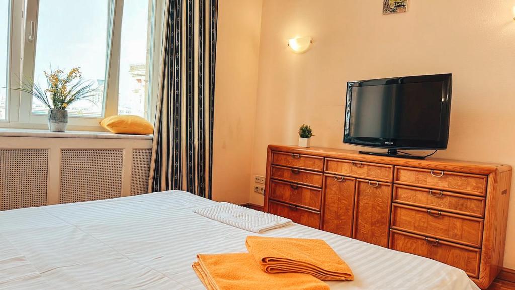 1 dormitorio con cama y vestidor con TV en Apartments Rentals Ukraine on Kreshchatik, en Kiev