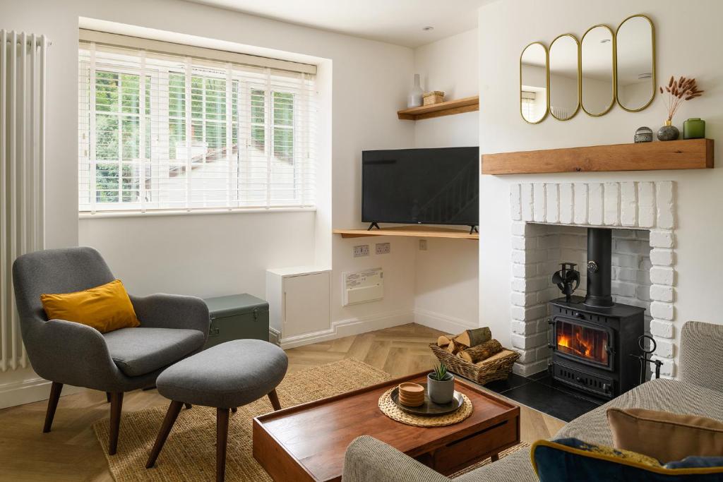 a living room with a fireplace and a tv at Heathercliffe Cottage, Snowdonia National Park in Penmaen-mawr