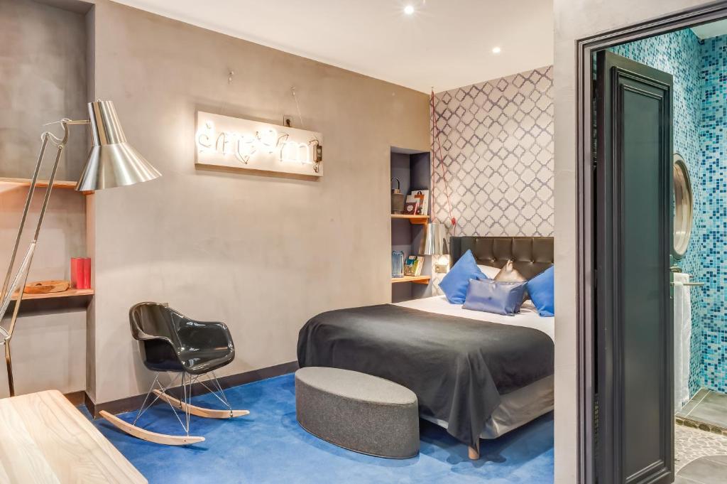1 dormitorio con 1 cama, 1 silla y 1 lámpara en ZE Hotel, en París