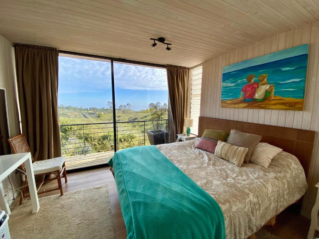 a bedroom with a bed and a large window at Hermosa y acogedora parcela cerca de viñas y playa in Algarrobo