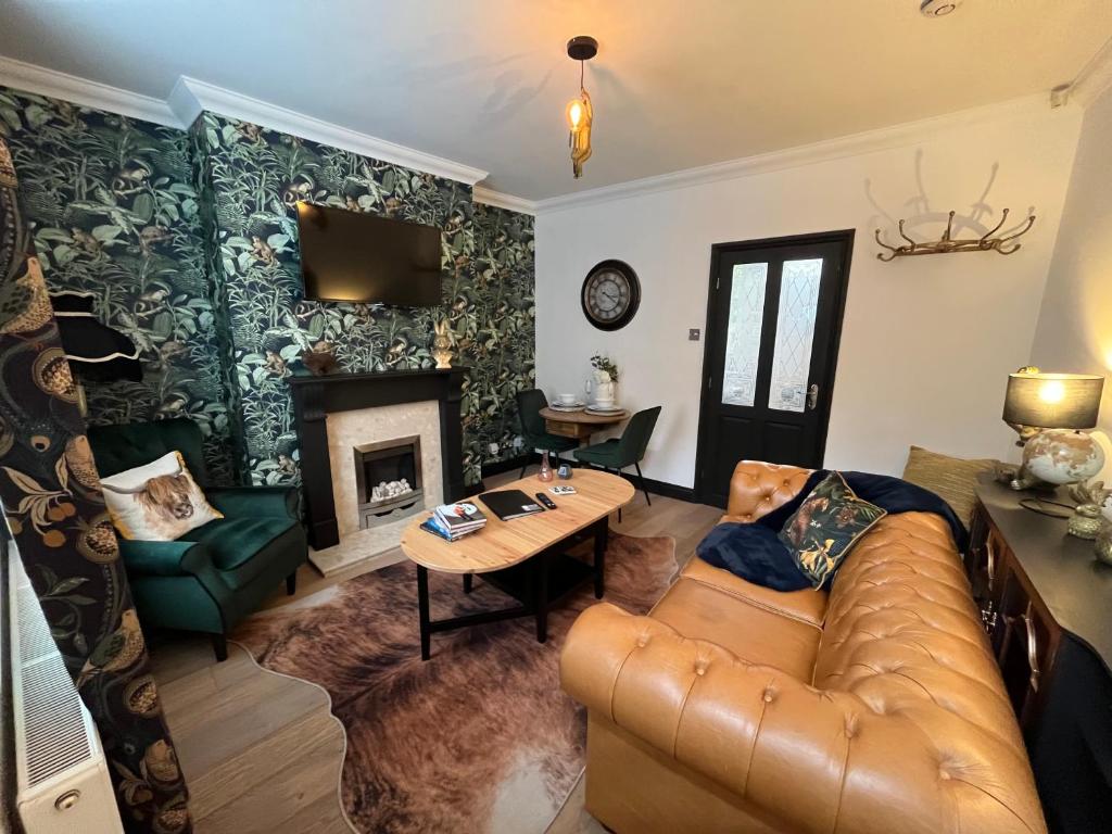 a living room with a couch and a fireplace at Contemporary & Chic inner terrace 5 mins from Barnsley town centre in Barnsley
