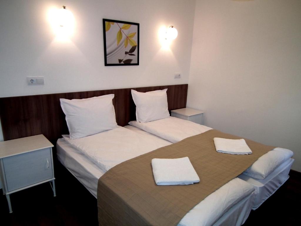 Dos camas en una habitación de hotel con toallas. en White House, en Veliko Tŭrnovo