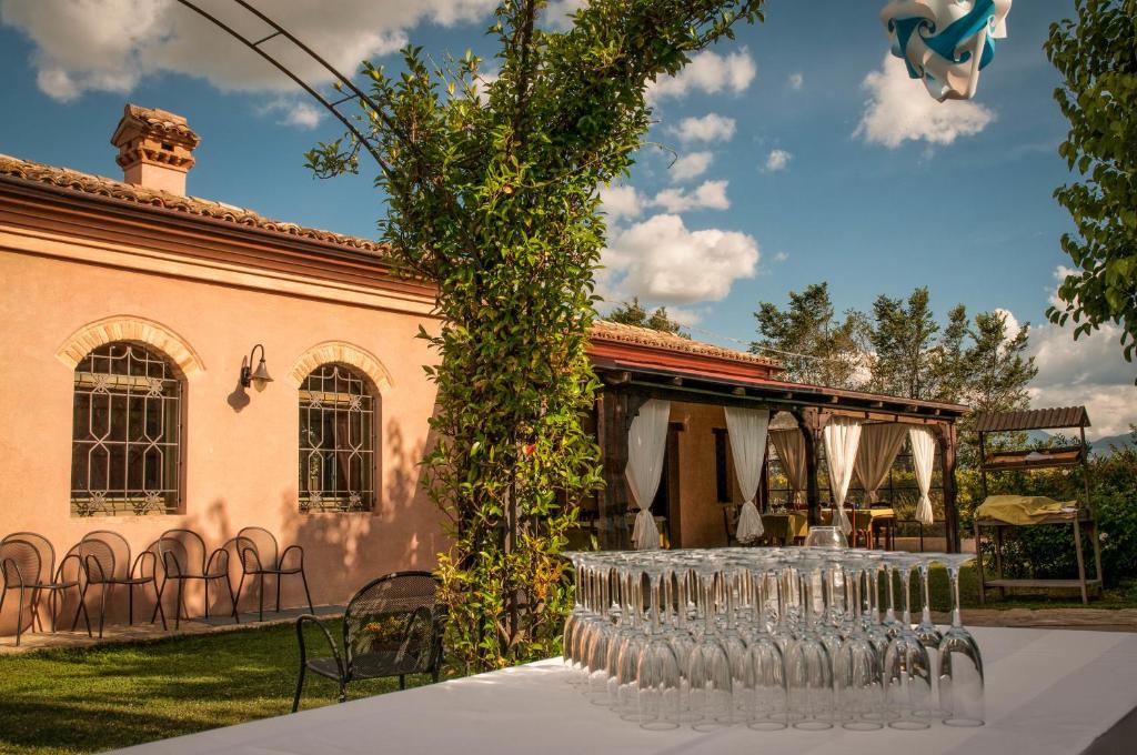 a group of wine glasses on a table in front of a building at Vittoria Il Graditempo Country House in Rosora