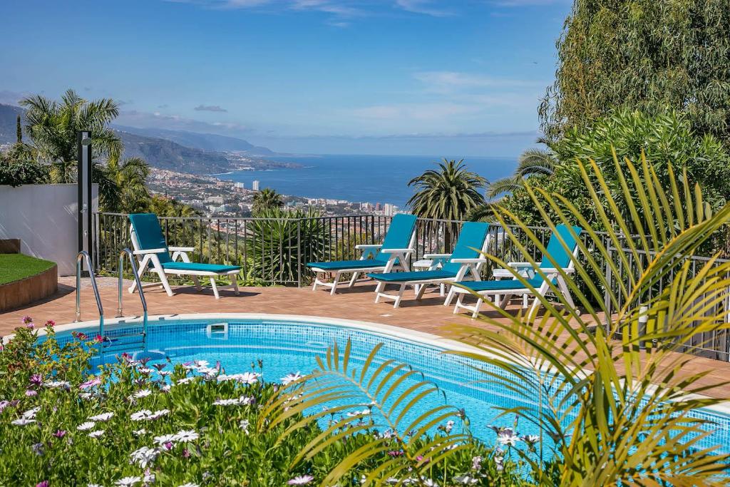 einen Pool mit Stühlen und Meerblick in der Unterkunft Residencial Vista Panoramica in Santa Úrsula