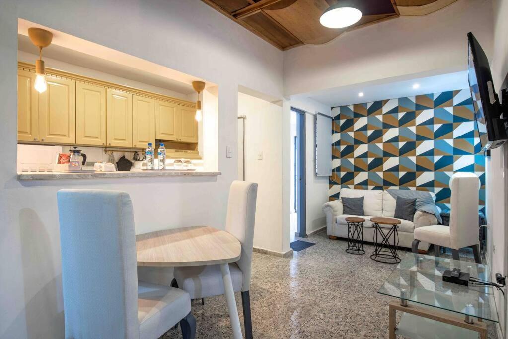 a kitchen and a living room with a table and chairs at Escape Apartment in Gazcue Close to Colonial Zone in Santo Domingo