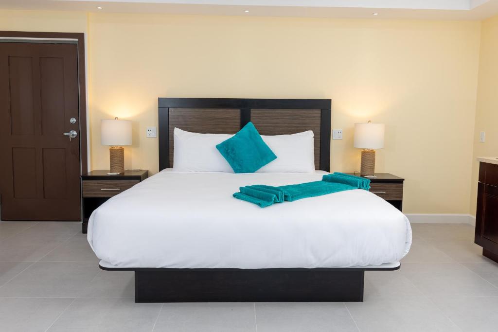 una camera da letto con un grande letto bianco con cuscini blu di The New View Inn a Tortola Island