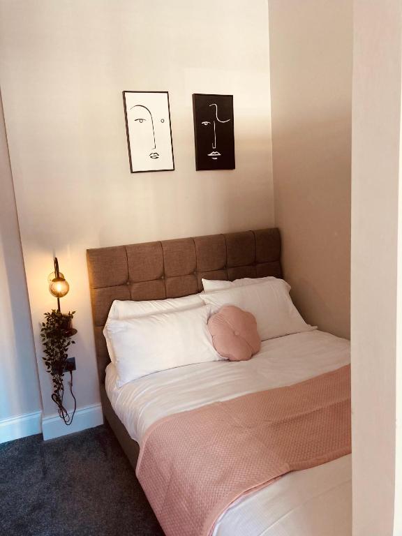 a bedroom with a bed with a pink pillow on it at 'Fairfield' at stayBOOM in Lancaster
