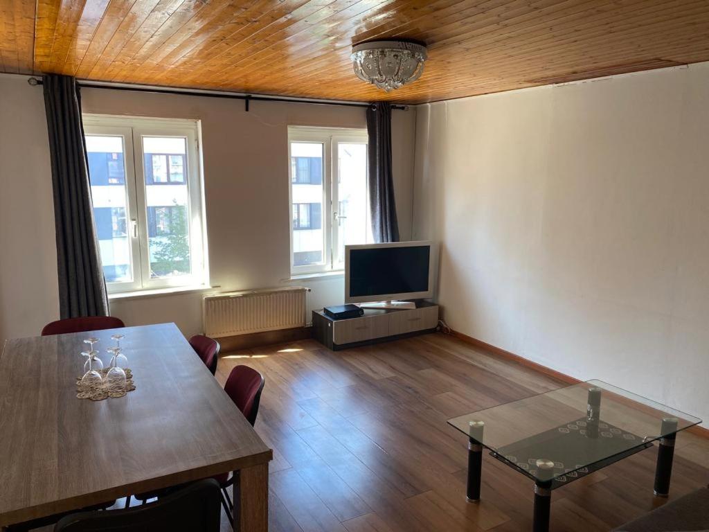a living room with a table and a television at Appartement Ledeberg in Ghent