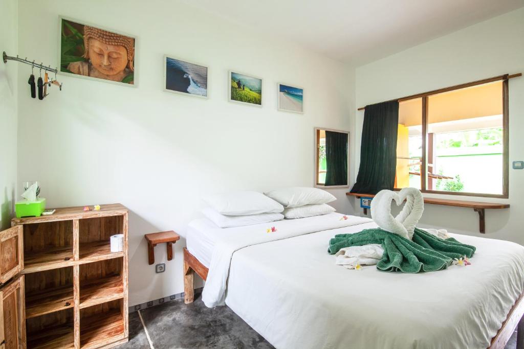 a bedroom with two beds and a window at Blue Coco in Keramas