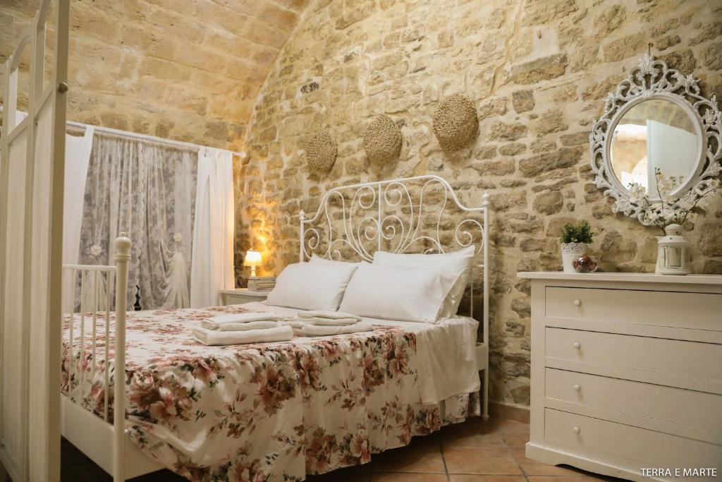 een slaapkamer met een bed en een stenen muur bij Terra e Marte casa vacanza in Bari