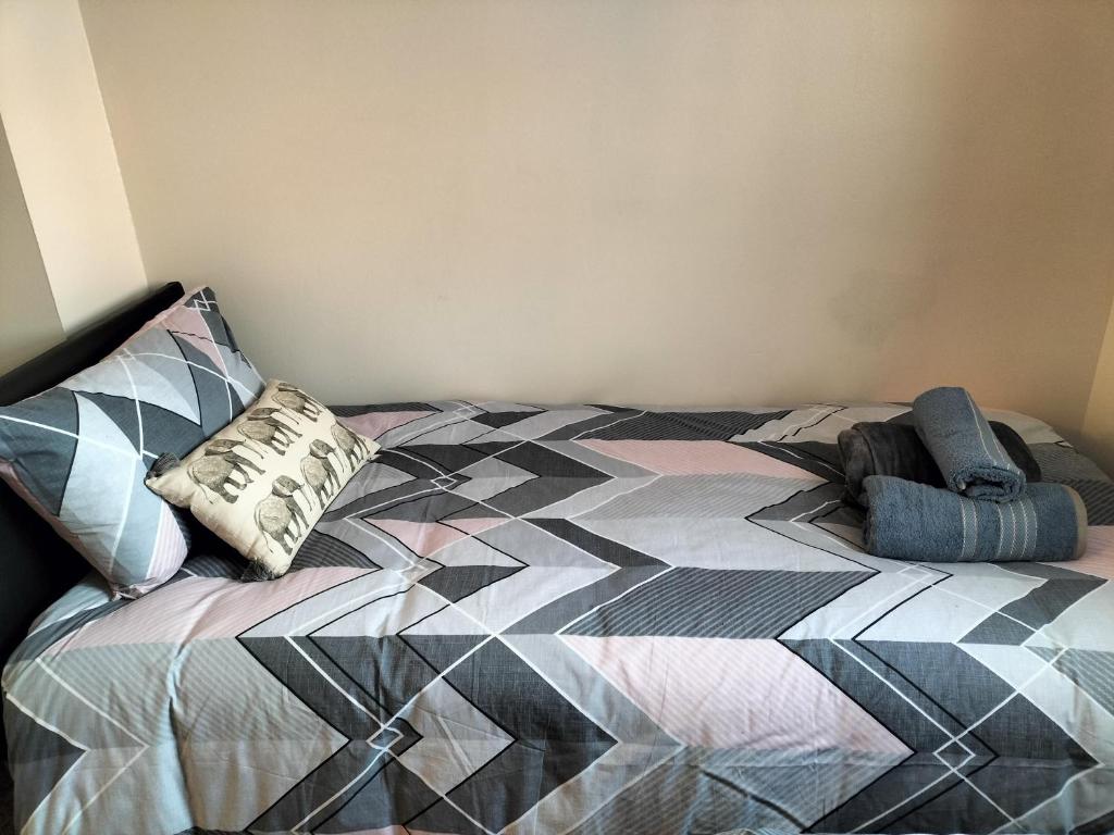 um quarto com uma cama com uma colcha colorida em Remaj Service Accommodation, Sleep 7 em Dagenham