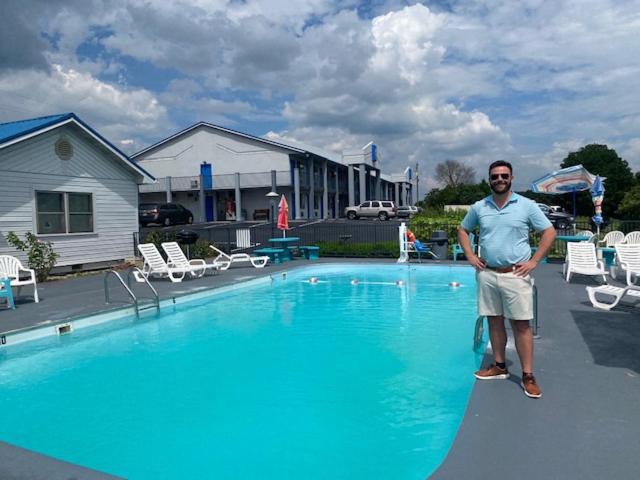 Ein Mann steht vor einem Schwimmbad. in der Unterkunft Smokies Inn - New Linens & Ultrafast WIFI - Friendliest Hospitality Guaranteed! in Kodak