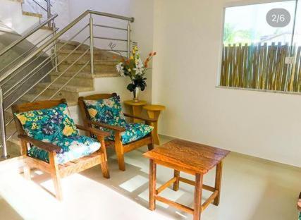 a living room with two chairs and a table at Aconchego dos Netos 2 - PRAIA DOS 3 COQUEIROS in Marau
