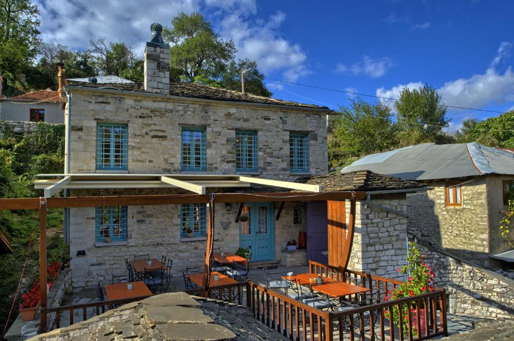 a stone house with a porch and a patio at Virginia in Asprangeloi