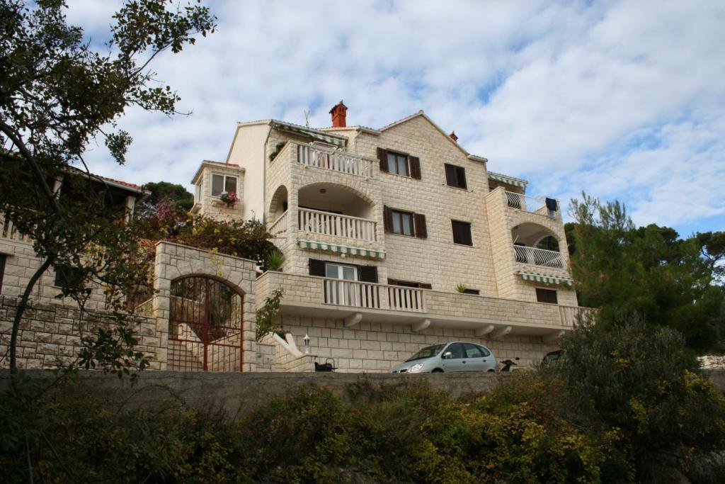 une voiture blanche garée devant un bâtiment dans l'établissement Apartments with a parking space Postira, Brac - 727, à Postira