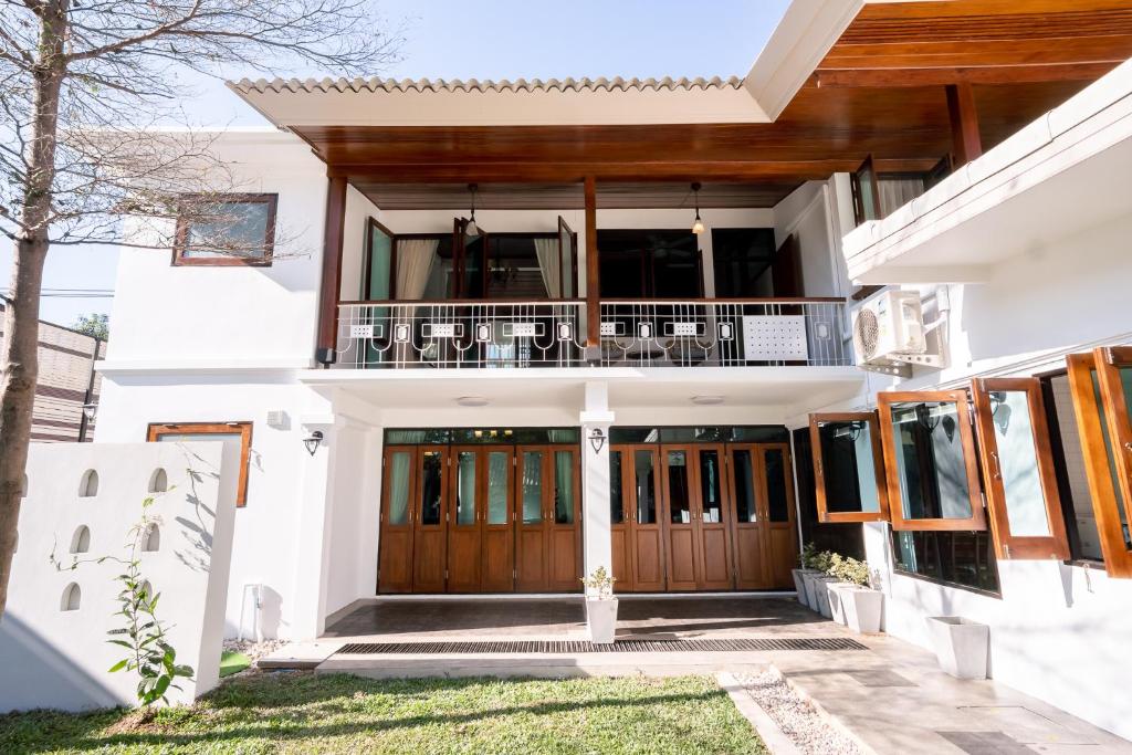 Cette maison dispose de portes en bois et d'un balcon. dans l'établissement Stay @ Na Maeping บ้านส่วนตัวริมแม่น้ำปิง, à Chiang Mai
