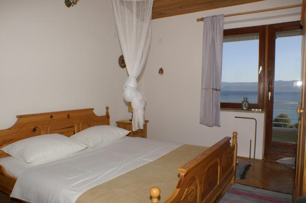 a bedroom with a bed with a view of the ocean at Apartments by the sea Duce, Omis - 945 in Duće