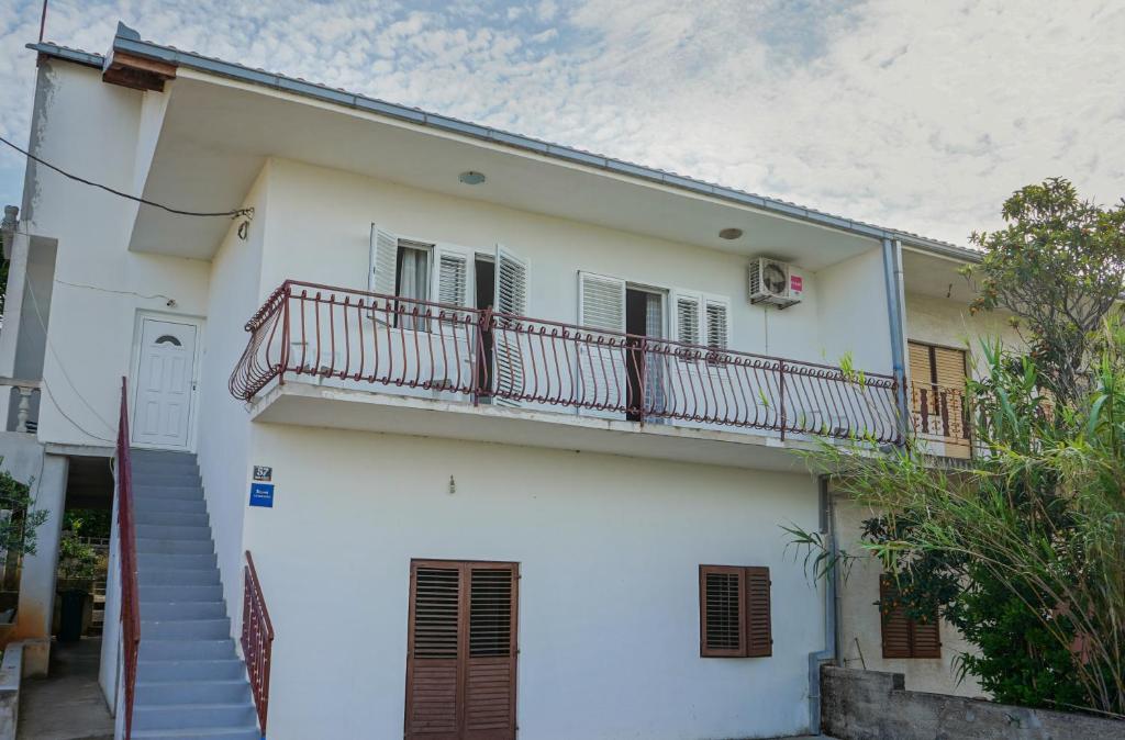 een wit huis met een balkon en een trap bij Apartments with a parking space Slatine, Ciovo - 973 in Slatine